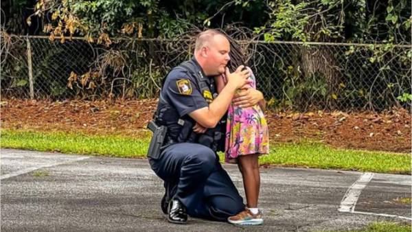 Police chief consoles crying child during the arrest of child's father